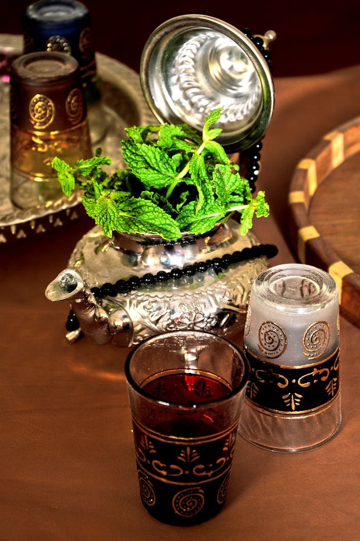 Elegant arrangement of traditional Moroccan mint tea with ornate glasses and teapot.