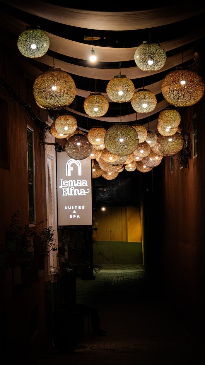 Cozy alley illuminated by decorative lanterns and a spa sign at night.